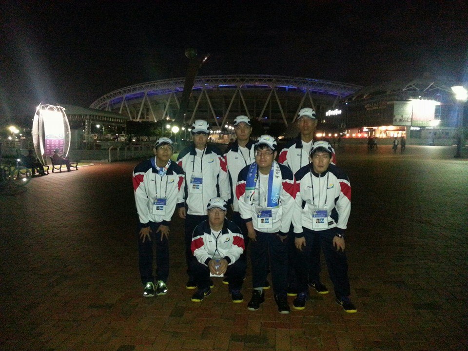 Basketball team group photo outside stadium at night