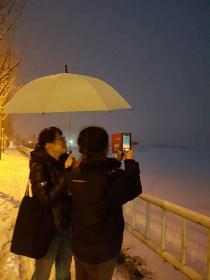 2 friends under an umbrella in the snow