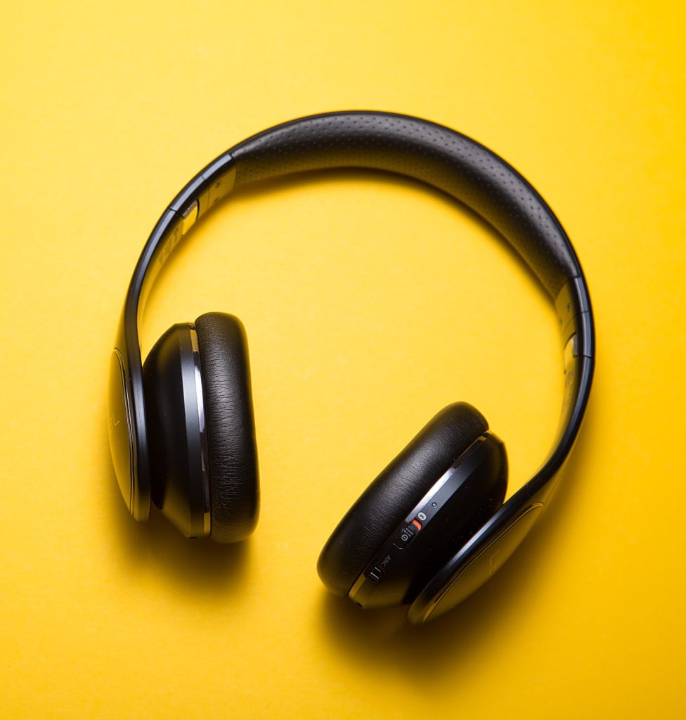 노란색 표면에 검은색 귀를 다 덮는 헤드폰 사진. 
