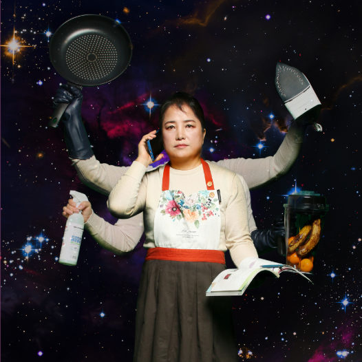 Yeonsu in an apron with 6 arms, each holding a domestic item with a dark galaxy background